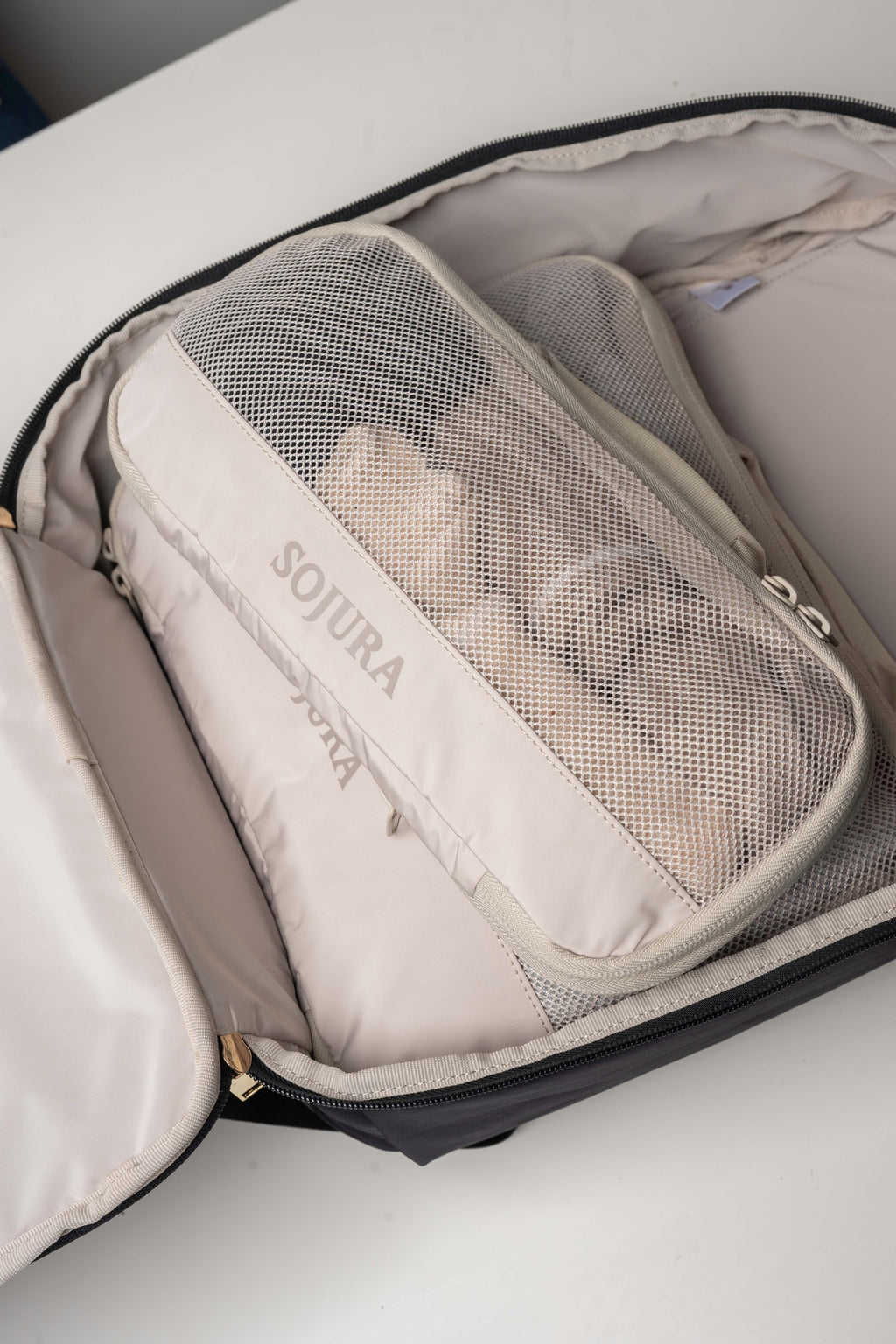 a medium and small packed sojura compression packing cube inside the sojura adella womens travel backpack