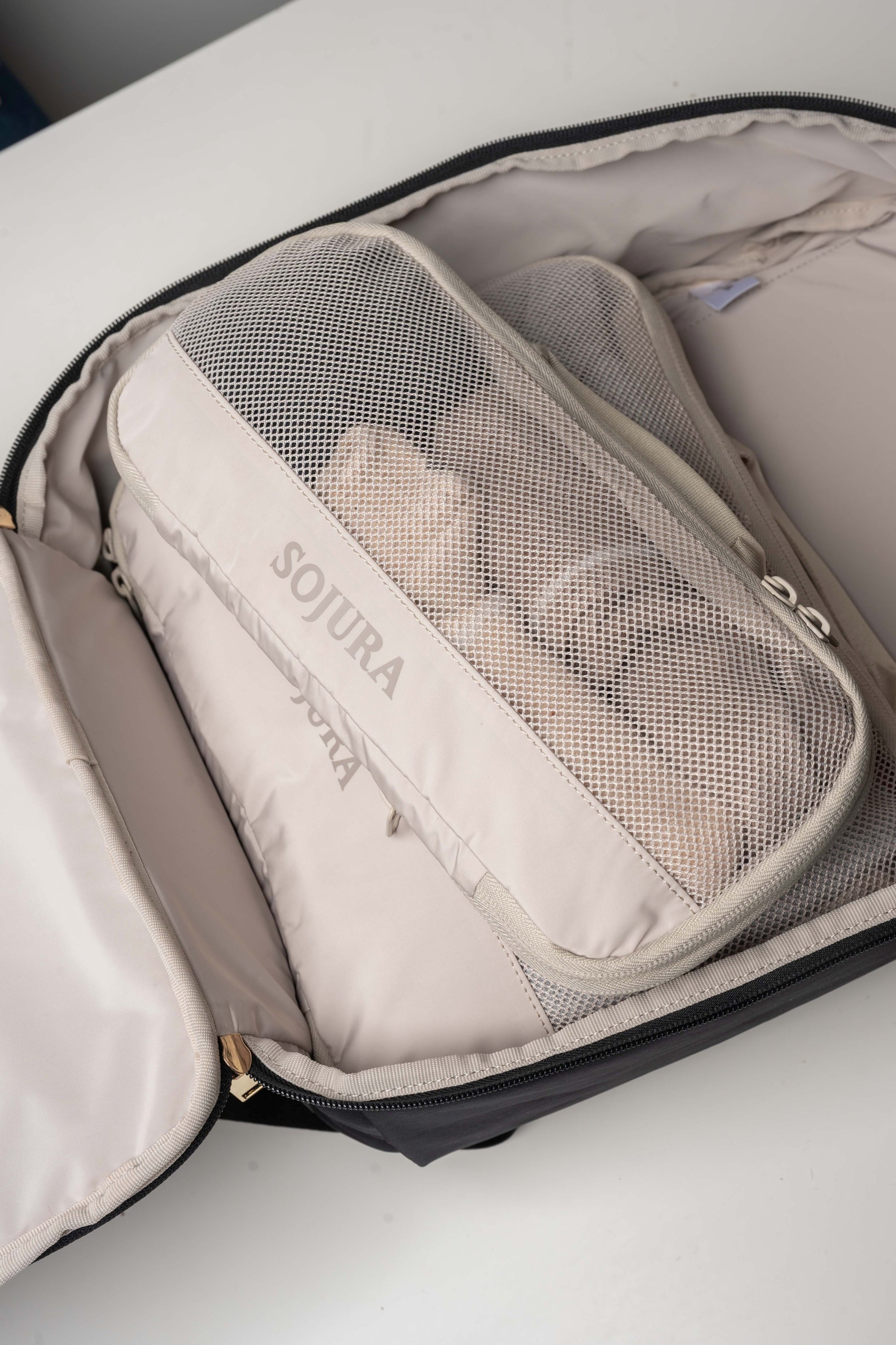 a medium and small packed sojura compression packing cube inside the sojura adella womens travel backpack