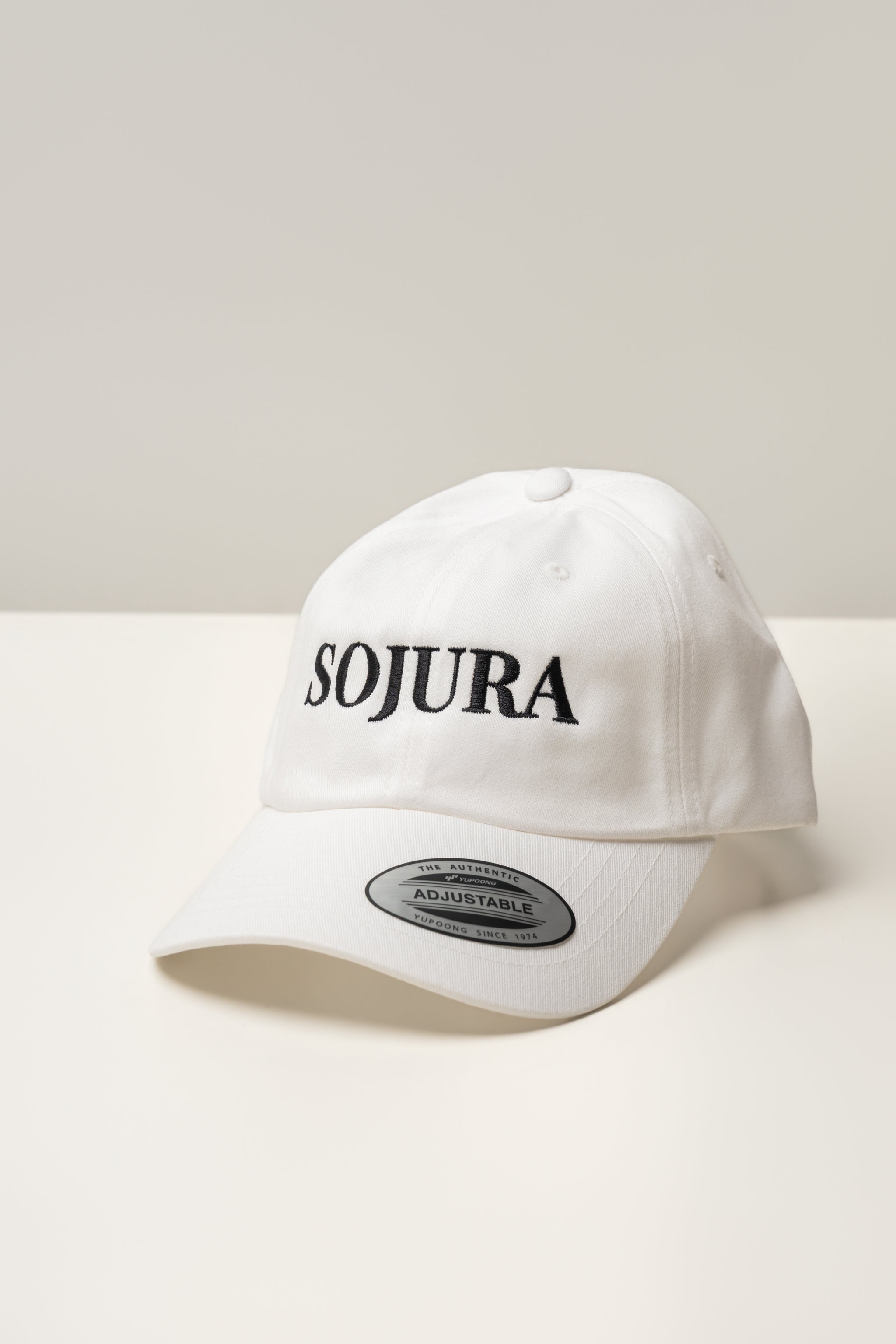 white ballcap with sojura logo embroidered across the front